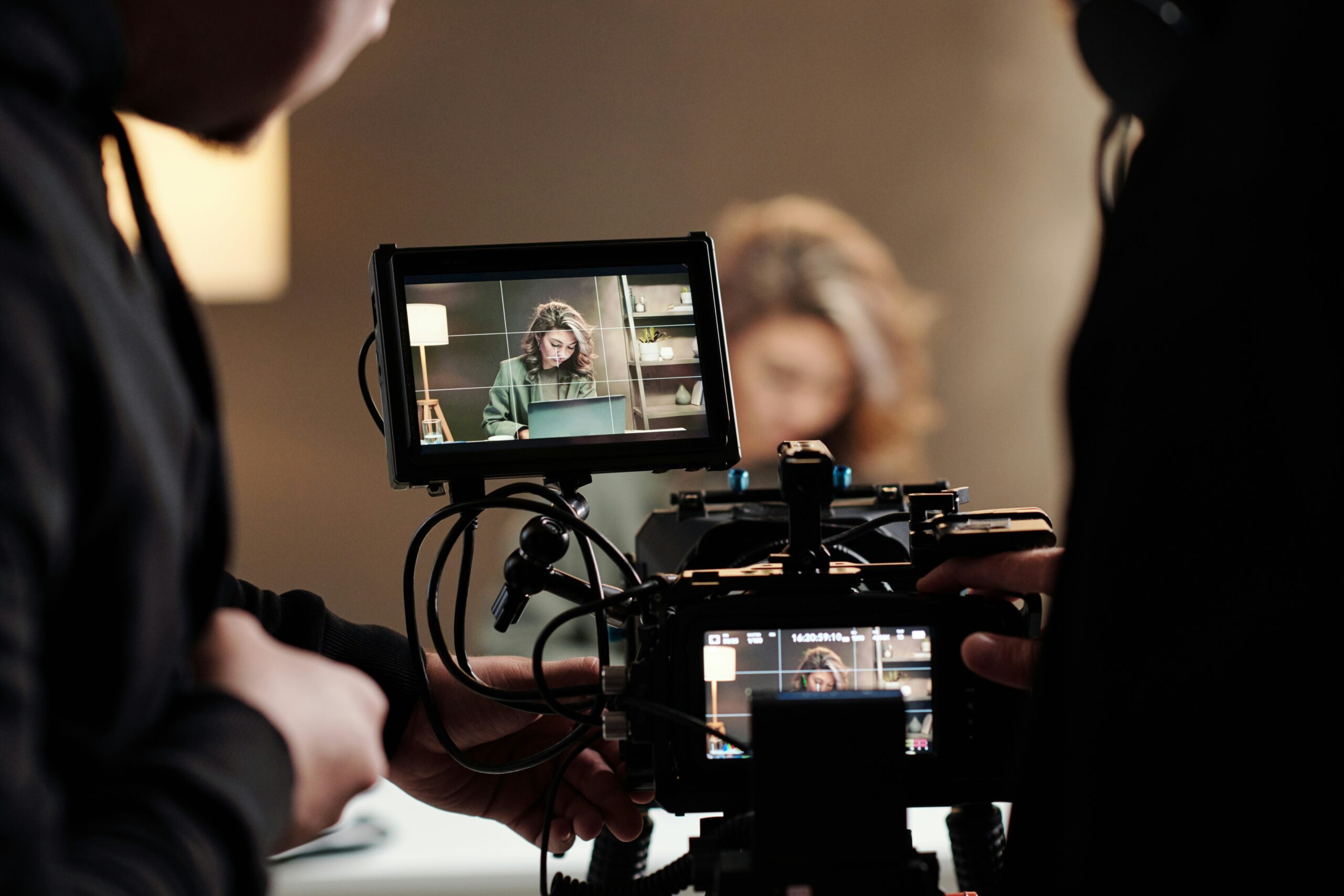 Camera operators framing a commercial shoot on a monitor; illustrative stock photograph