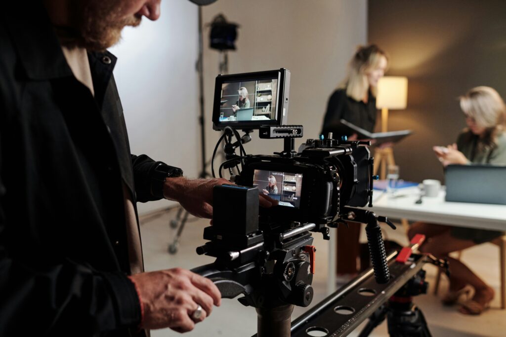 Production crew working around a camera in a studio; illustrative stock photograph