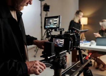 Production crew working around a camera in a studio; illustrative stock photograph