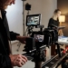 Production crew working around a camera in a studio; illustrative stock photograph